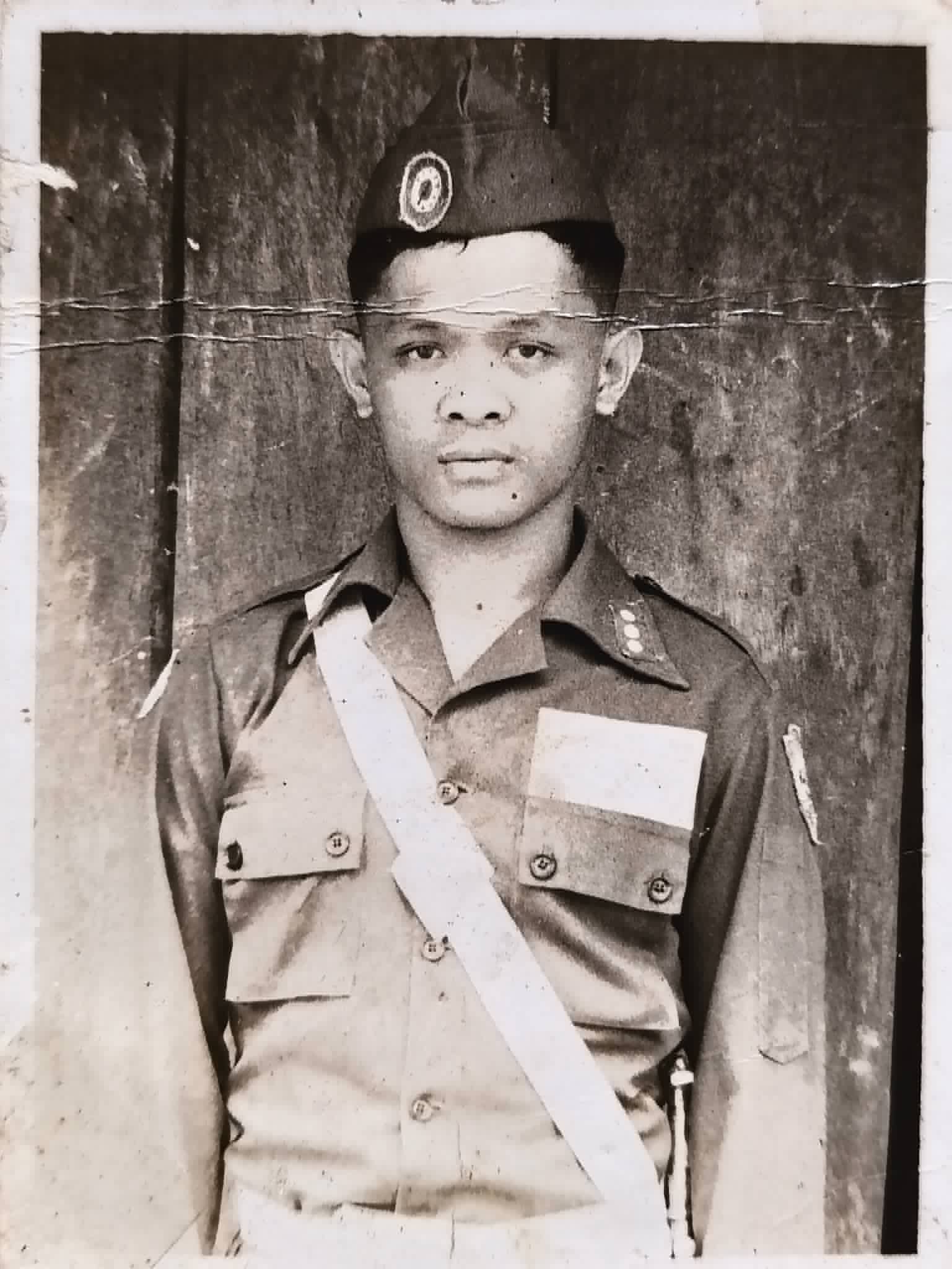 A black-and-white portrait of a young man wearing a uniform and beret.