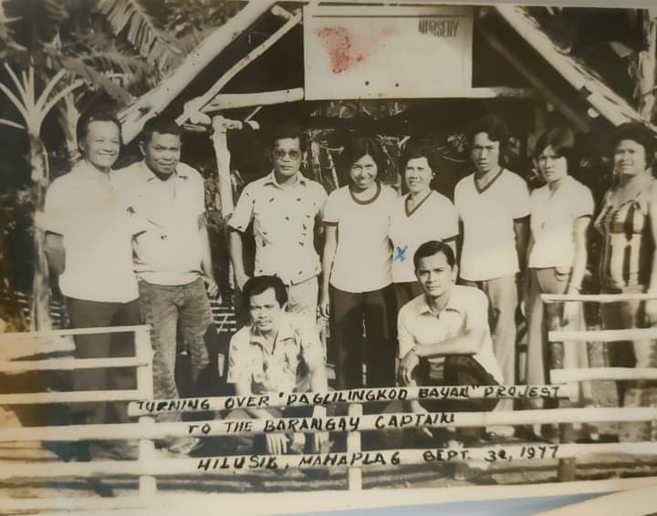 A group stands behind a bamboo structure during the turnover of a Paglilingkod Bayan project in Hilusig in 1977.